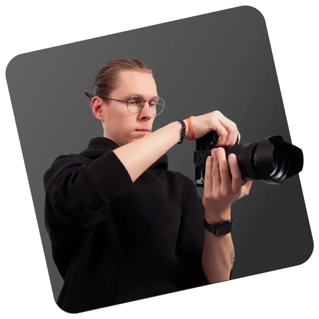 Mediengestalter im Rhein-Main-Gebiet richtet Systemkamera mit Teleobjektiv für ein Fotoshooting ein
