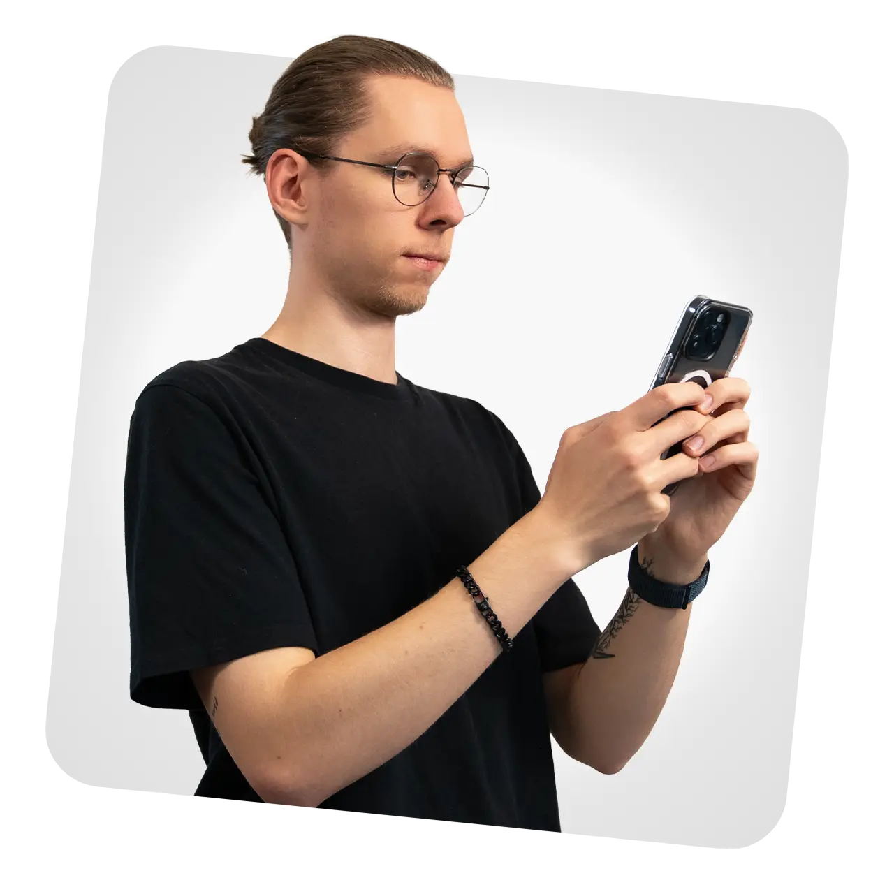 Das Bild zeigt eine Person mit einem Smartphone in der Hand vor einem weißen Hintergrund.