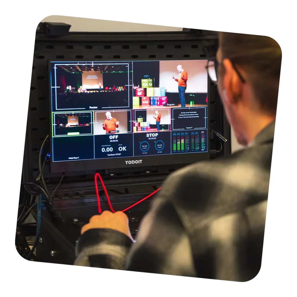 Blick über die Schulter auf einen Multi-Cam-Monitor mit Vorschau- und Programmbild während einer Livestream-Produktion
