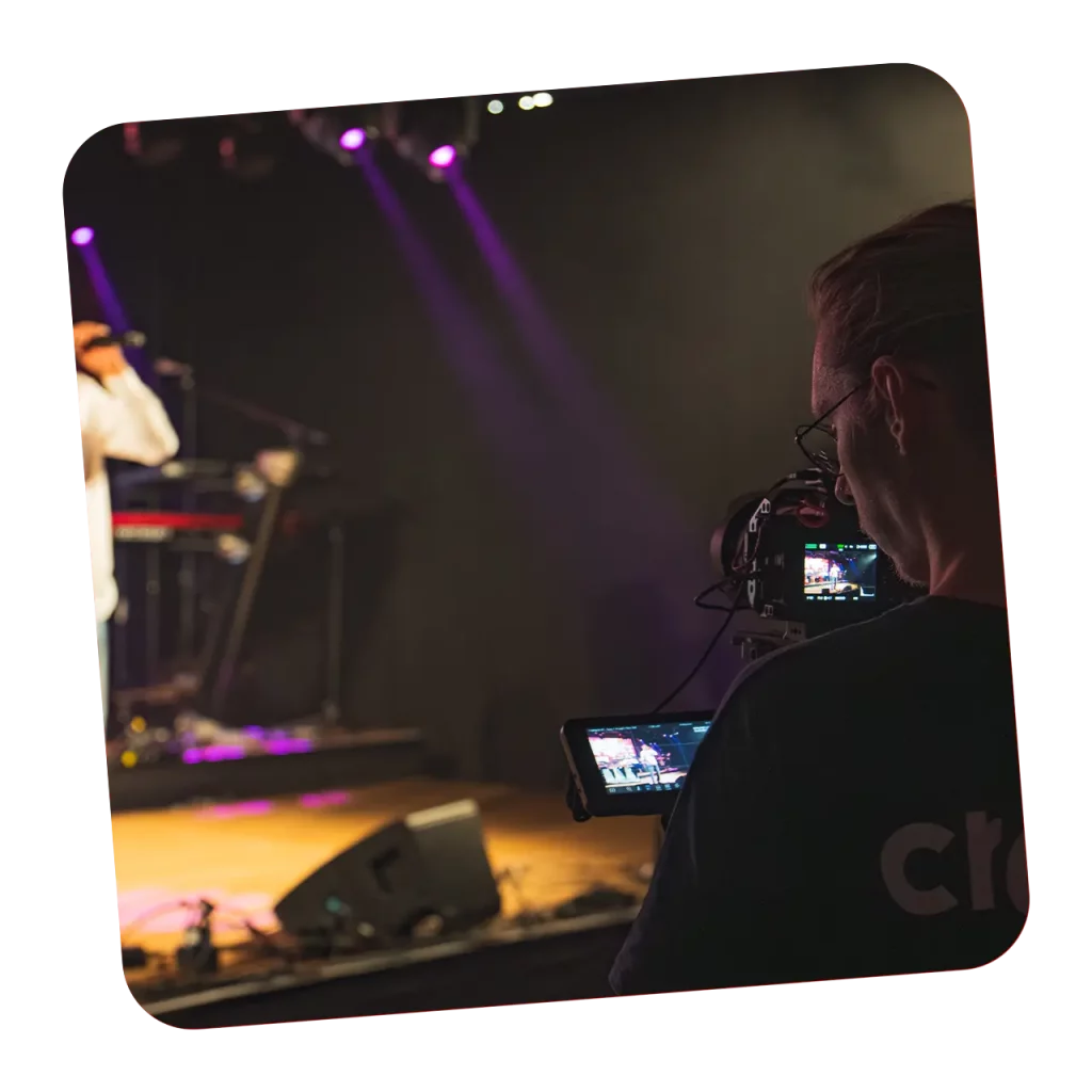 Kameramann filmt einen Auftritt auf einer Bühne mit einer Cinema-Kamera bei einer Videoproduktion